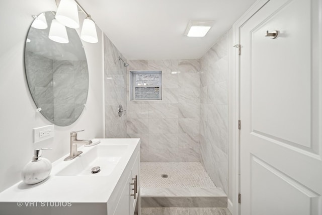 bathroom with vanity and tiled shower