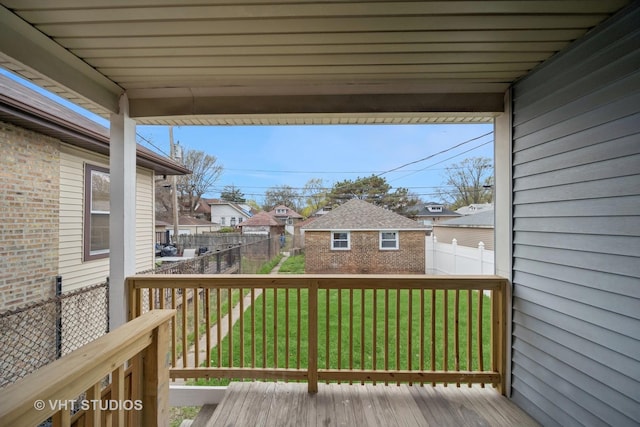 deck with a lawn, fence, a residential view, and an outdoor structure