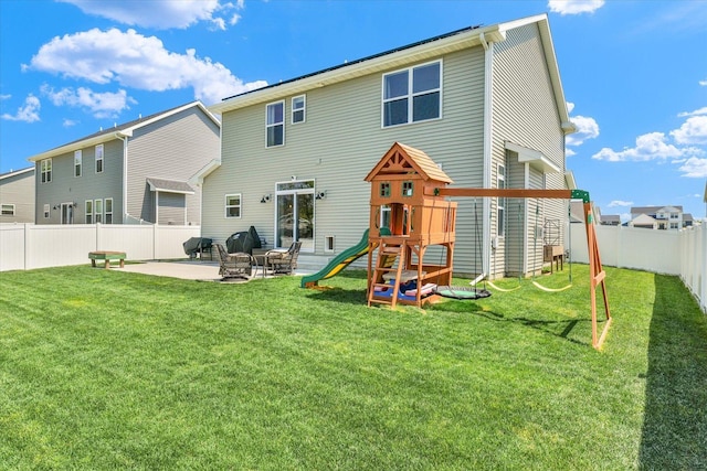 rear view of house with a fenced backyard, a playground, a patio, and a lawn