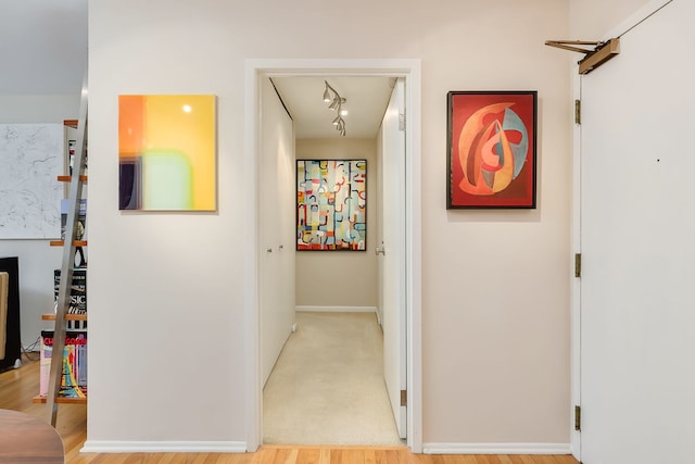 hall featuring baseboards and light wood-style flooring