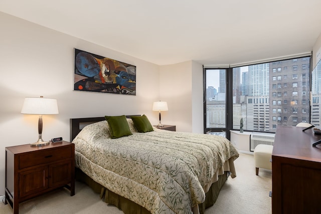 bedroom featuring light carpet, a city view, and a wall of windows