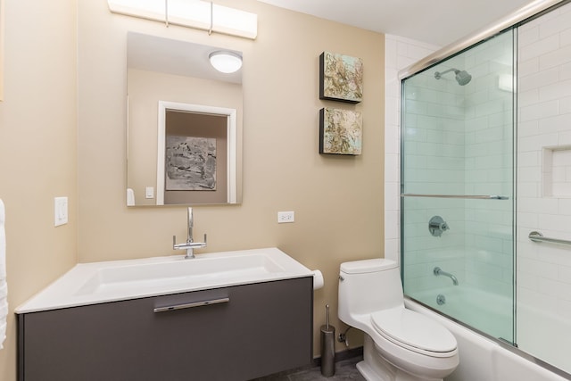bathroom featuring toilet, enclosed tub / shower combo, and vanity