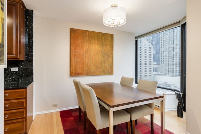 dining space featuring light wood-style floors and baseboards