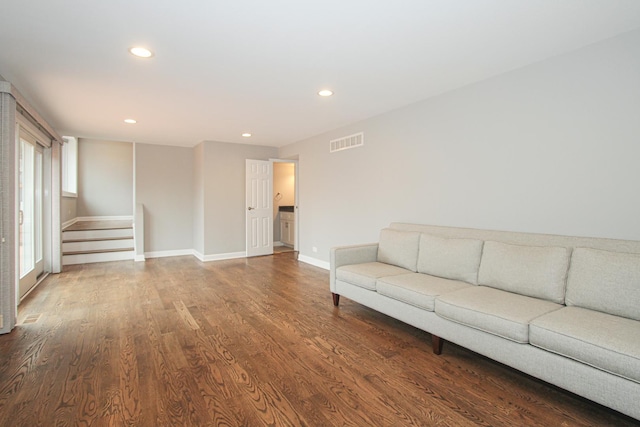 unfurnished living room with baseboards, visible vents, recessed lighting, wood finished floors, and stairs