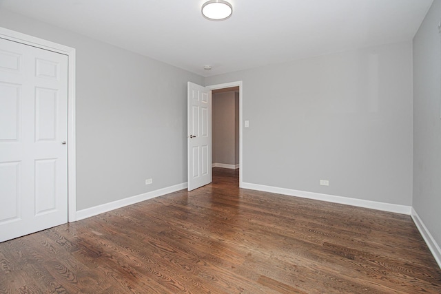 unfurnished bedroom featuring dark wood-type flooring and baseboards