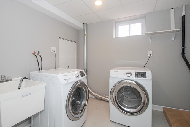 laundry area with light tile patterned floors, a sink, and independent washer and dryer