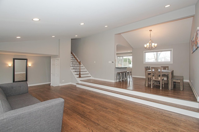 living area with recessed lighting, lofted ceiling, wood finished floors, a chandelier, and stairs