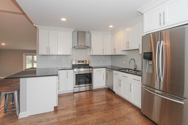 kitchen featuring dark countertops, wall chimney range hood, white cabinetry, and stainless steel appliances