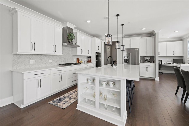 kitchen with dark wood-type flooring, wall chimney range hood, appliances with stainless steel finishes, and a sink