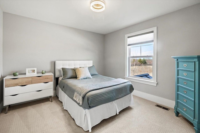 bedroom featuring visible vents, baseboards, and light carpet