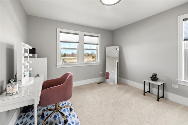 carpeted office space with visible vents and baseboards