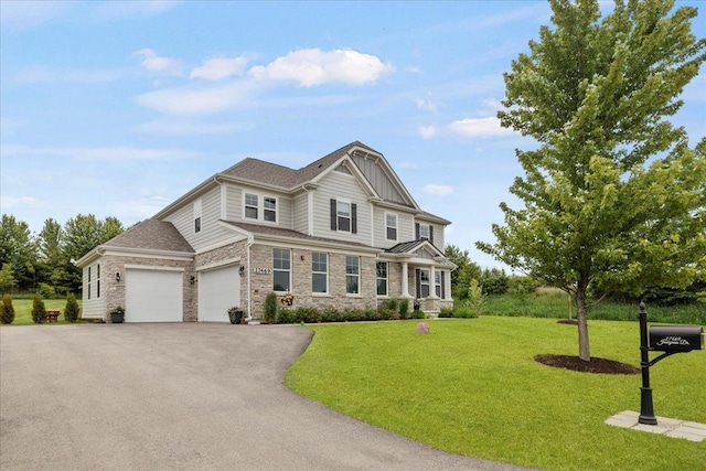 craftsman inspired home featuring aphalt driveway, stone siding, board and batten siding, a front yard, and a garage