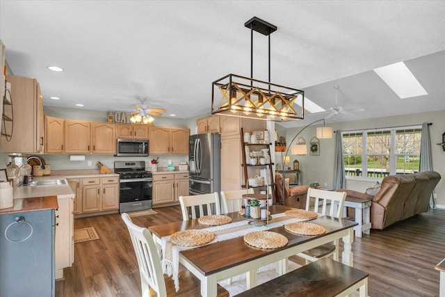 dining space featuring a skylight, recessed lighting, dark wood-type flooring, and ceiling fan