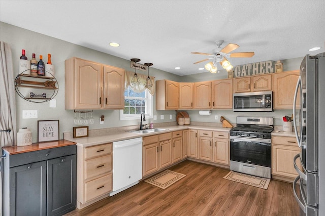 kitchen featuring light brown cabinets, stainless steel appliances, ceiling fan, and a sink