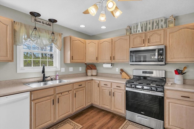 kitchen with stainless steel appliances, a sink, wood finished floors, ceiling fan, and light brown cabinets