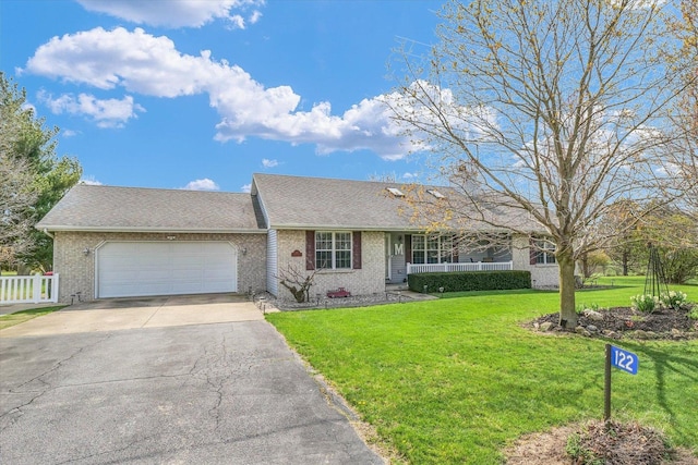 ranch-style home with a front lawn, fence, brick siding, an attached garage, and aphalt driveway