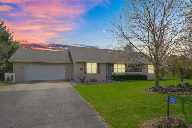 single story home with a lawn, driveway, roof with shingles, and a garage