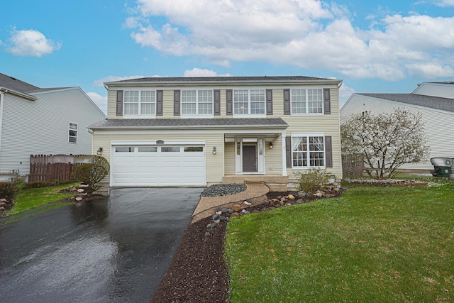 traditional-style home with a front yard, fence, an attached garage, and aphalt driveway