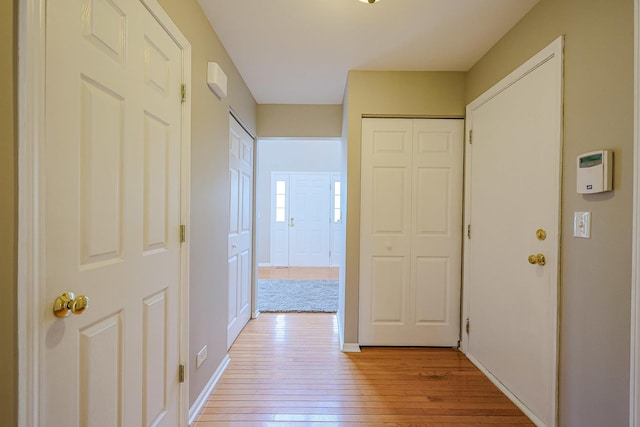 hall with light wood finished floors and baseboards
