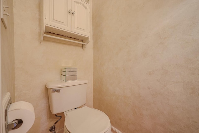 half bathroom with toilet and baseboards