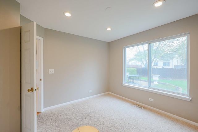 empty room with carpet, visible vents, recessed lighting, and baseboards
