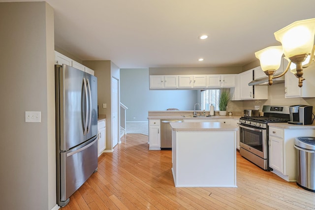 kitchen with appliances with stainless steel finishes, light countertops, and white cabinets