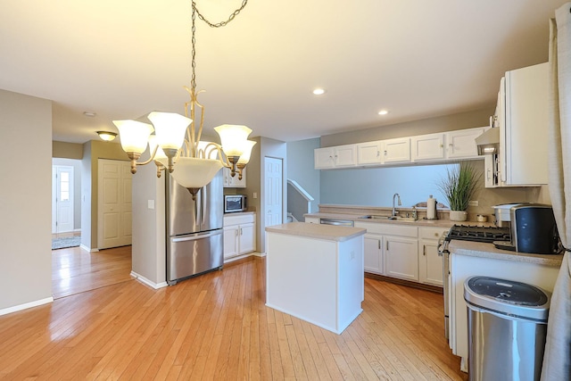 kitchen featuring recessed lighting, a sink, light countertops, white cabinets, and appliances with stainless steel finishes