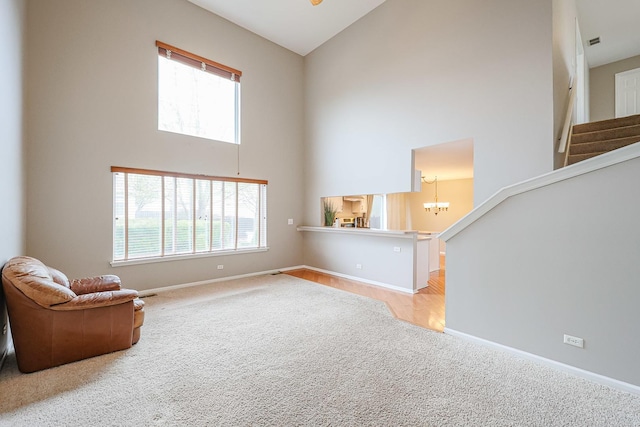 unfurnished room featuring baseboards, high vaulted ceiling, a wealth of natural light, and light colored carpet