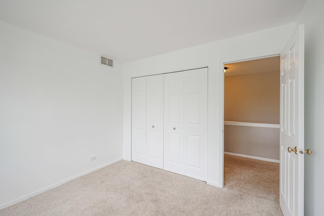 unfurnished bedroom with carpet flooring, a closet, visible vents, and baseboards