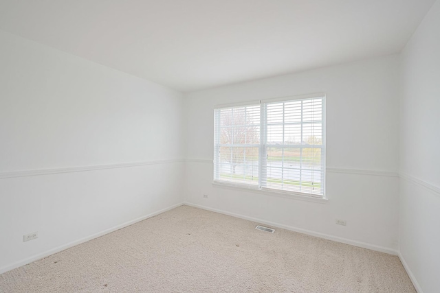 spare room with visible vents, baseboards, and carpet floors