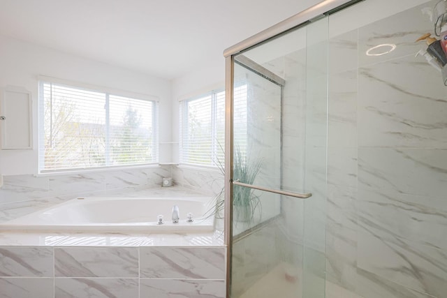 full bath featuring a bath and a marble finish shower