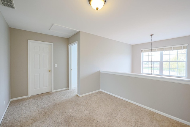 carpeted empty room with visible vents and baseboards