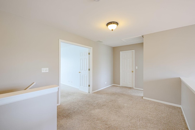 spare room featuring baseboards and light carpet