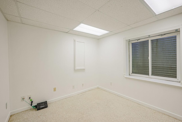 carpeted empty room with baseboards and a paneled ceiling