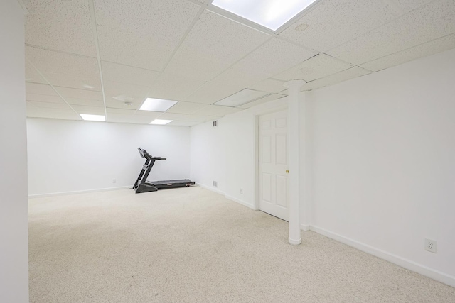 interior space featuring baseboards, carpet flooring, and a paneled ceiling