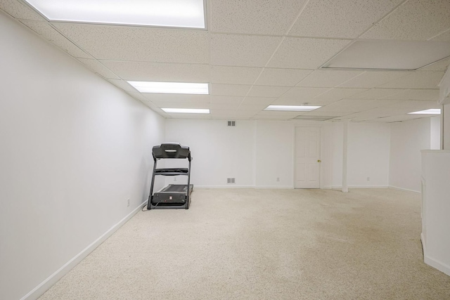finished below grade area with baseboards, carpet, and a drop ceiling