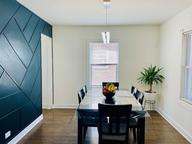dining space featuring baseboards and dark wood-style floors