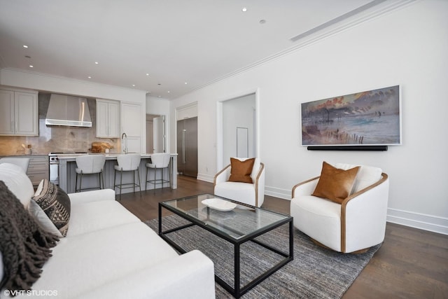 living area with baseboards, ornamental molding, dark wood-type flooring, and recessed lighting