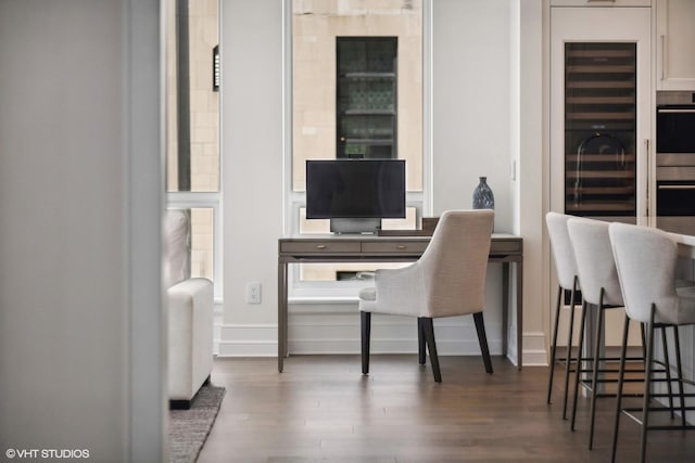 office area featuring baseboards, radiator heating unit, and wood finished floors