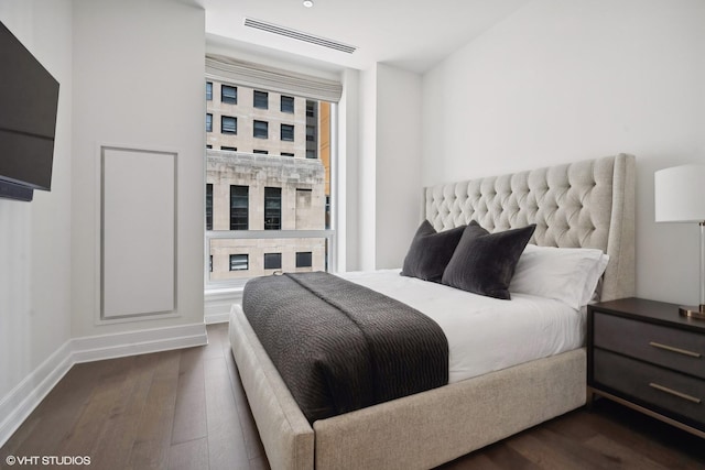 bedroom with baseboards, visible vents, and dark wood-style floors