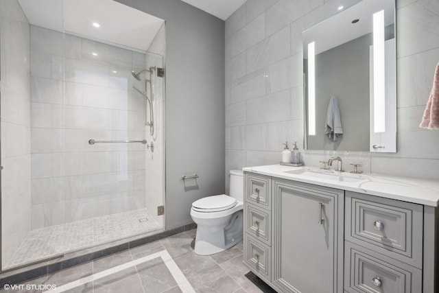 full bathroom featuring tiled shower, tile walls, toilet, baseboards, and vanity