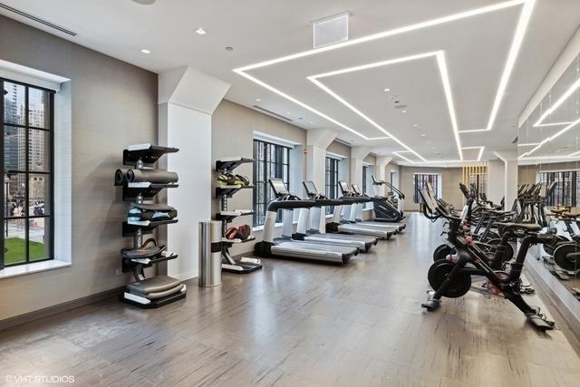 exercise room with wood finished floors, visible vents, and plenty of natural light