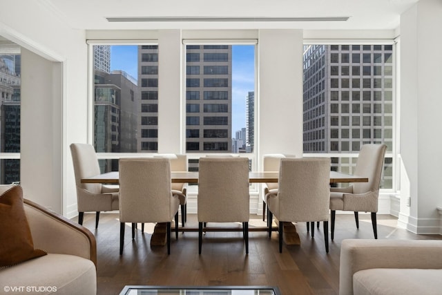 dining space with wood finished floors and a view of city