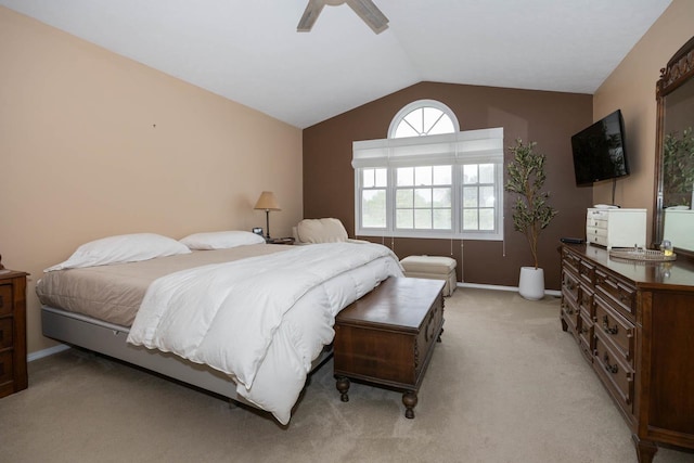 bedroom featuring a ceiling fan, light carpet, baseboards, and vaulted ceiling