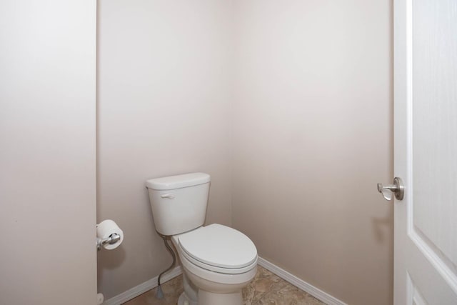 bathroom with toilet and baseboards