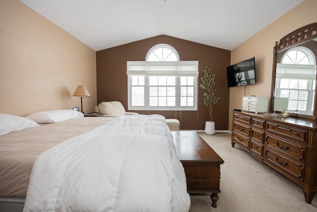 bedroom with light colored carpet and lofted ceiling