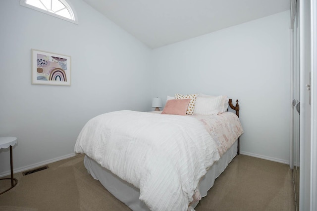 bedroom with lofted ceiling, carpet floors, baseboards, and visible vents