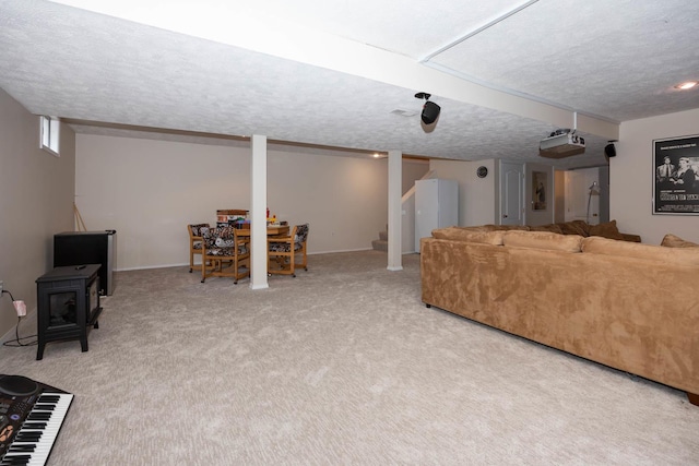 carpeted living area with a wood stove, a textured ceiling, stairs, and baseboards