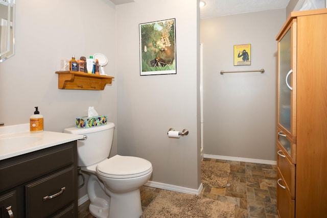 bathroom with vanity, baseboards, and stone finish floor