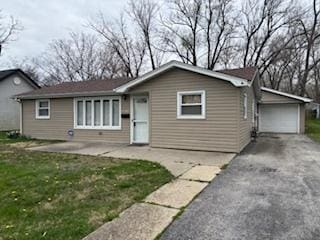 ranch-style home with a garage and aphalt driveway